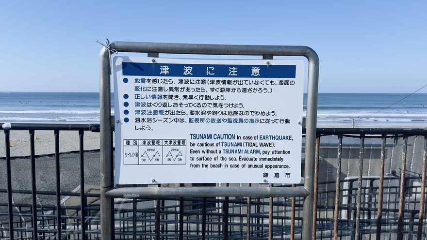Tsunami caution sign at the Yuigahama beach fence
