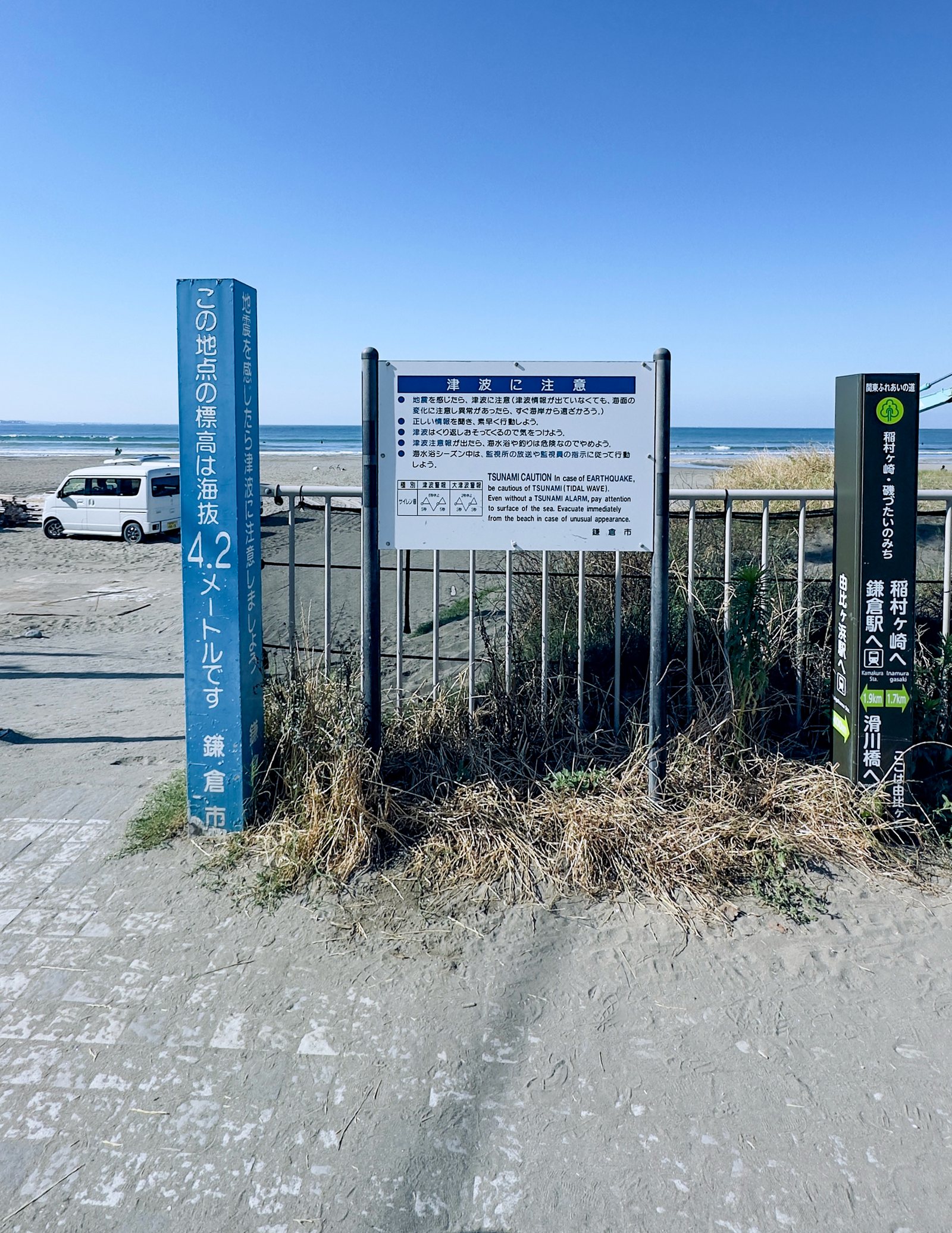 Current condition at Yuigahama Beach: text-heavy blue and white tsunami warning boards